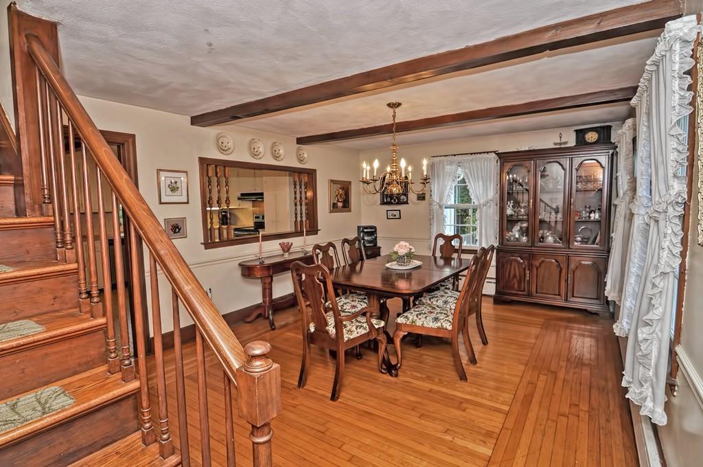 7 Rosedale Drive Bristol, RI 02809 - Photo 5 of 23 a view of a dining room and livingroom with furniture wooden floor a rug a flat screen tv a painting and a chandelier