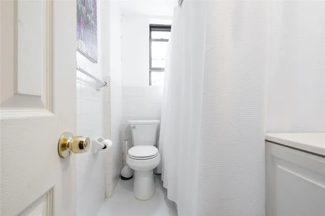 a white toilet sitting next to a shower curtain