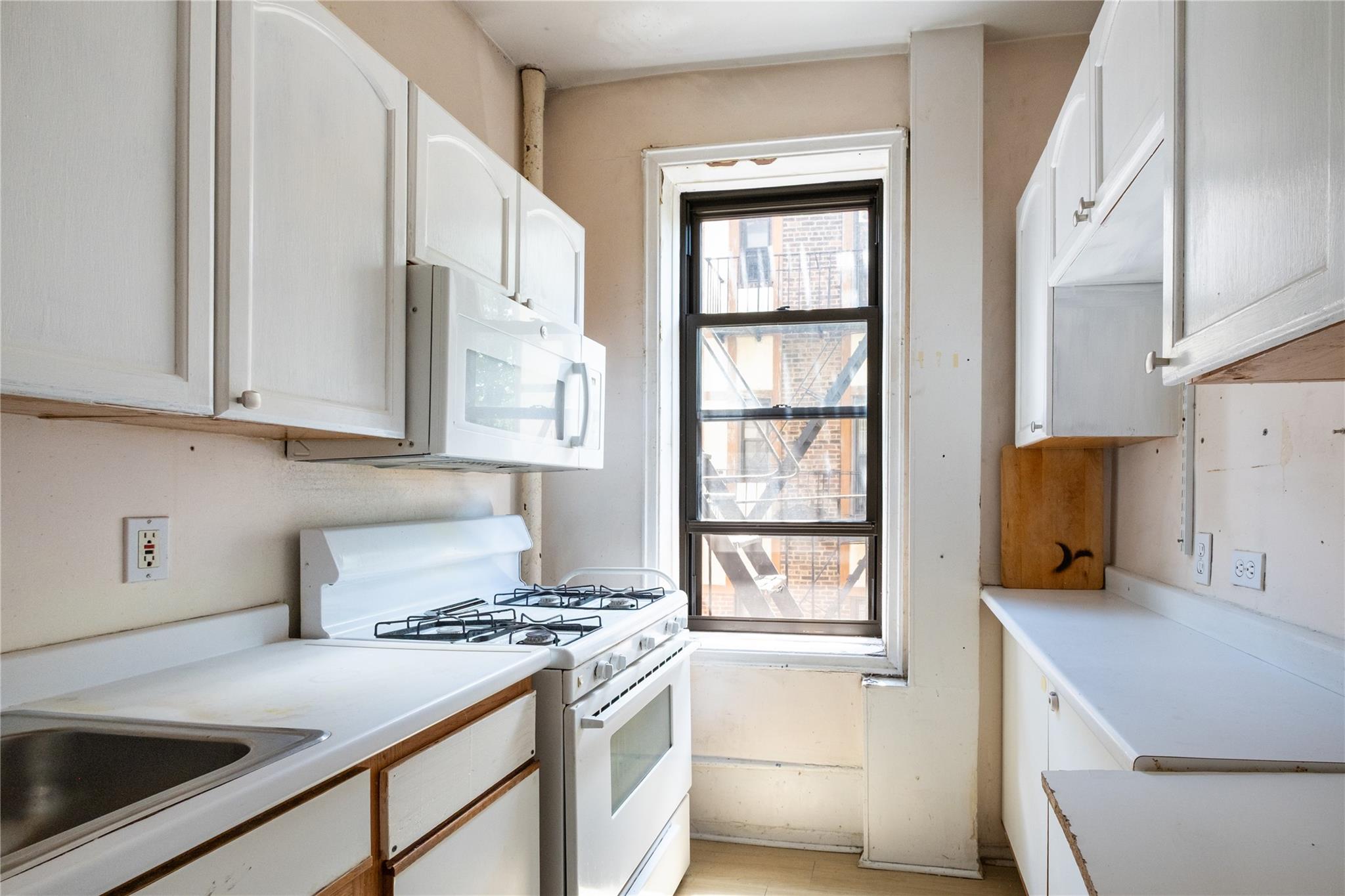 760 Brady Avenue, Unit 417 Bronx, NY 10462 - Photo 18 of 27 a kitchen with stainless steel appliances a stove a sink and a refrigerator with white cabinets