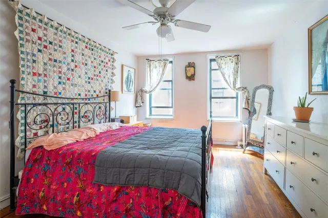 a bedroom with a bed and a dresser with the shoe rack