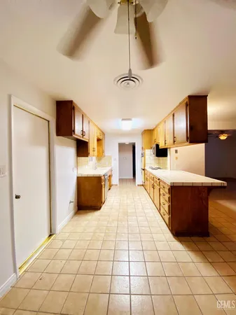 a large room with a bed and a view of kitchen
