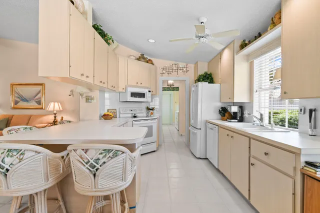 a kitchen with a stove a sink dishwasher and a refrigerator with white cabinets
