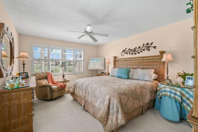 a bed sitting in a spacious bedroom next to a window