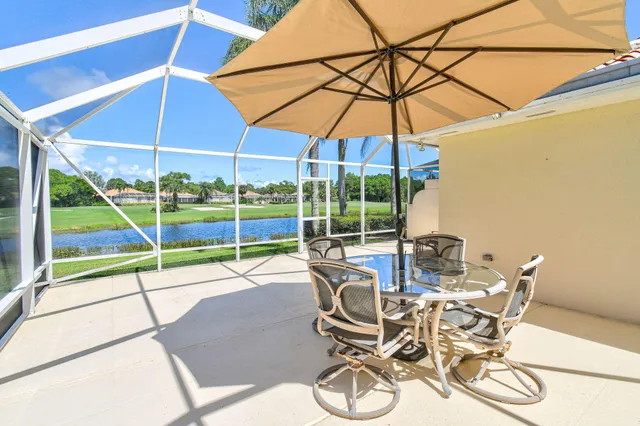 a view of a patio with table and chairs under an umbrella