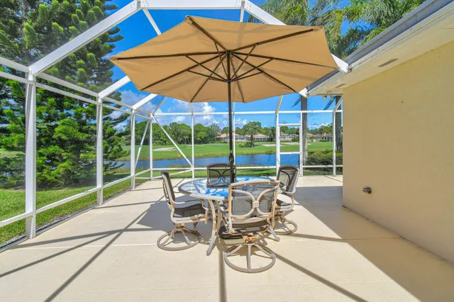 a view of a patio with table and chairs under an umbrella