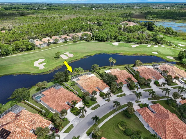 an aerial view of a residential houses with outdoor space and a lake view