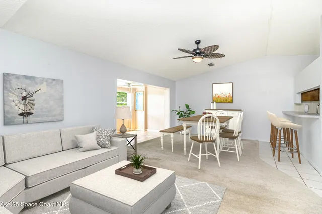 a living room with furniture a chandelier and a dining table