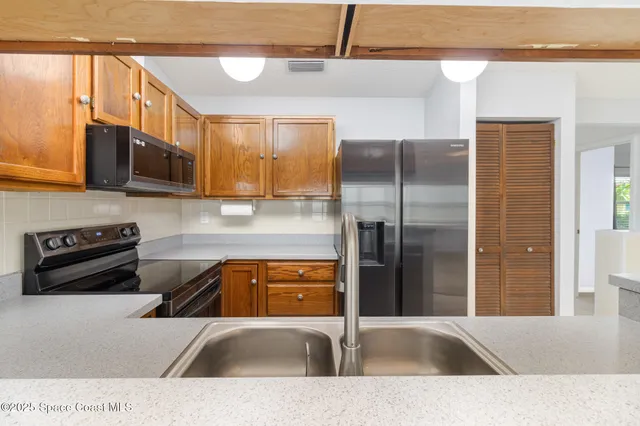 a kitchen with a refrigerator a sink and a microwave