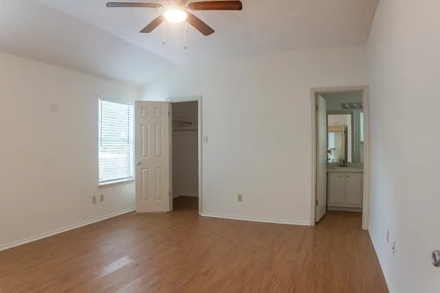 an empty room with a window and a fan