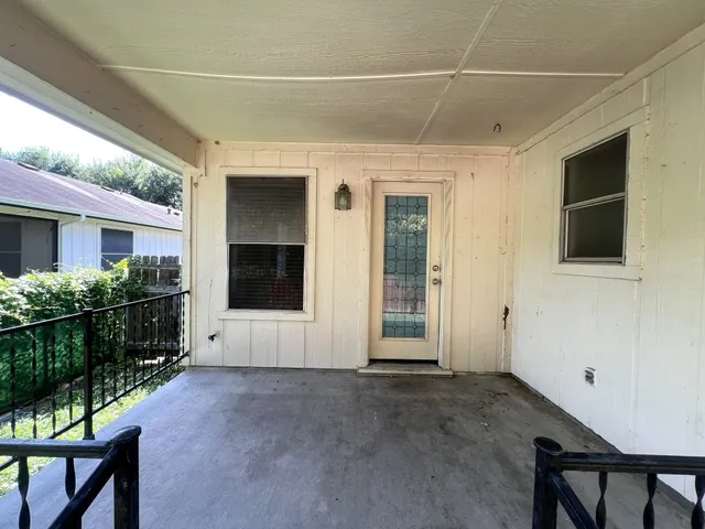 a view of backyard with wooden fence and a large tree