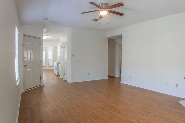 a view of an empty room with a window and fireplace