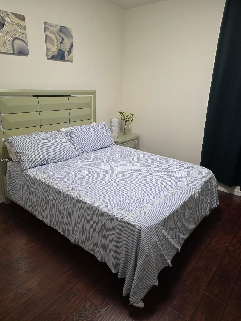 15764 Southwest 101st Street Miami, FL 33196 - Photo 20 of 27 a bedroom with a bed and wooden floor