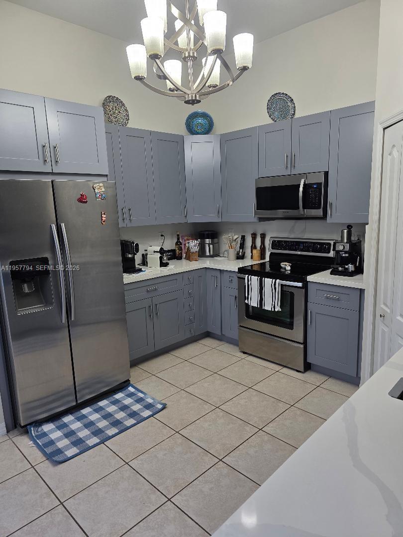 15764 Southwest 101st Street Miami, FL 33196 - Photo 3 of 27 a kitchen with stainless steel appliances granite countertop a sink a stove top oven a counter space and cabinets
