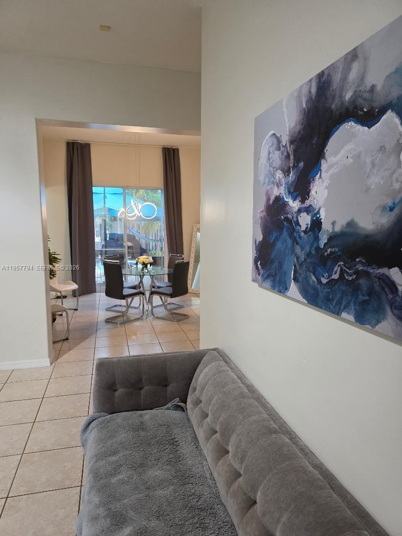 15764 Southwest 101st Street Miami, FL 33196 - Photo 9 of 27 a living room with furniture and a large mirror next to a window