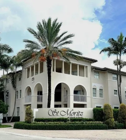 a front view of white house with yard and parking