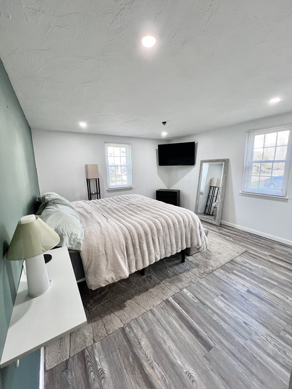 39 Christopher Drive, Unit B Stoughton, MA 02072 - Photo 14 of 38 a bedroom with a bed and wooden floor