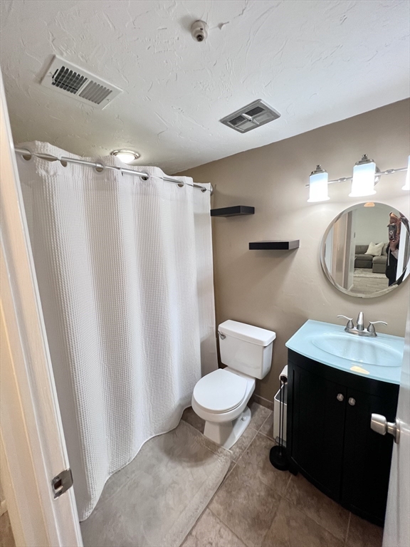 39 Christopher Drive, Unit B Stoughton, MA 02072 - Photo 19 of 38 a bathroom with a granite countertop sink toilet a mirror a vanity and shower