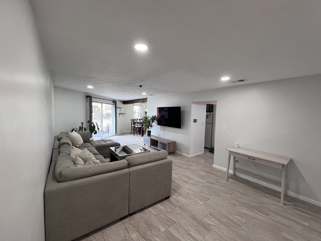39 Christopher Drive, Unit B Stoughton, MA 02072 - Photo 3 of 38 a living room with furniture and a flat screen tv