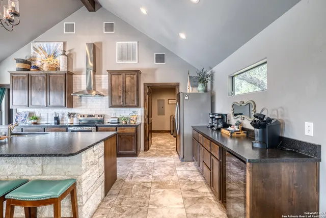 a kitchen with kitchen island granite countertop lots of counter top space and stainless steel appliances