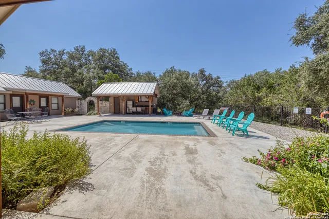 a view of a swimming pool with lawn chairs under an umbrella
