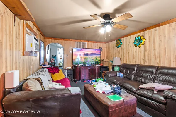 a living room with furniture a chandelier and a dining table