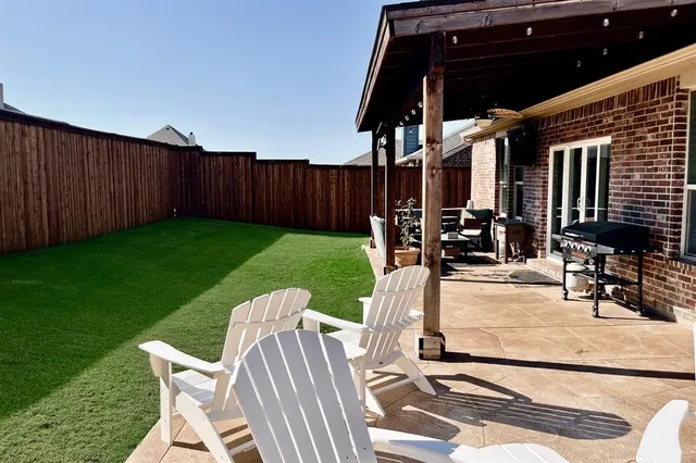 a view of a patio with table and chairs with wooden floor and fence