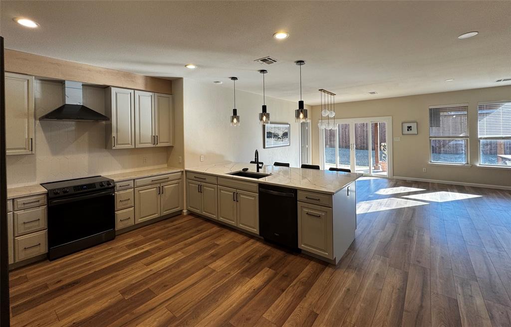 14917 Spruce Street Little Elm, TX 75068 - Photo 5 of 13 a large kitchen with stainless steel appliances granite countertop a stove and a sink