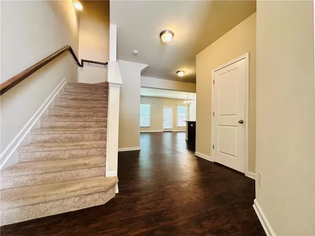 a view of a hallway with wooden floor and staircase