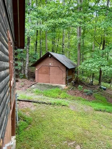 a backyard of a house with plants and large trees