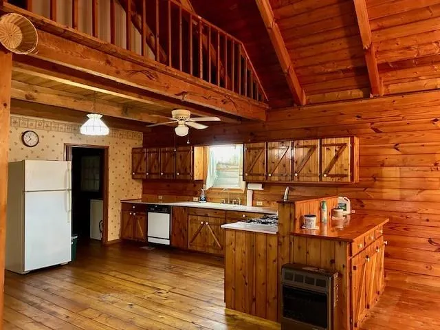 a view of a kitchen with stainless steel appliances wooden cabinets and a stove top oven
