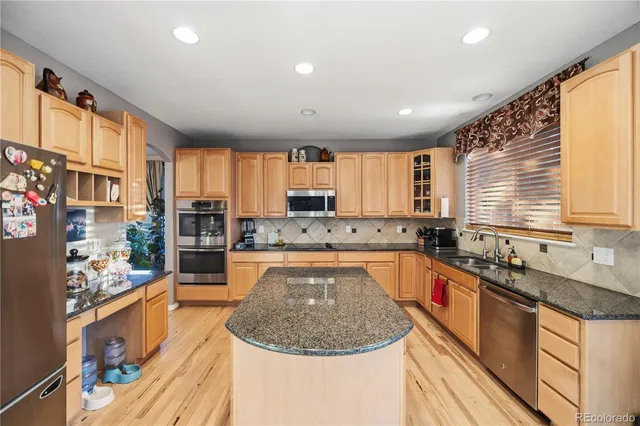 a kitchen with stainless steel appliances granite countertop a refrigerator and a stove top oven