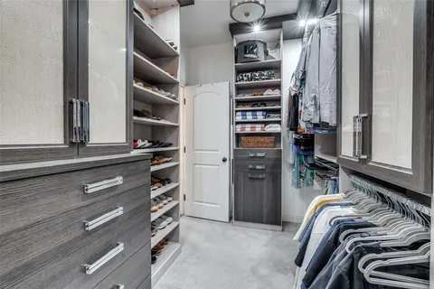 a view of walk in closet with clothes and shoes