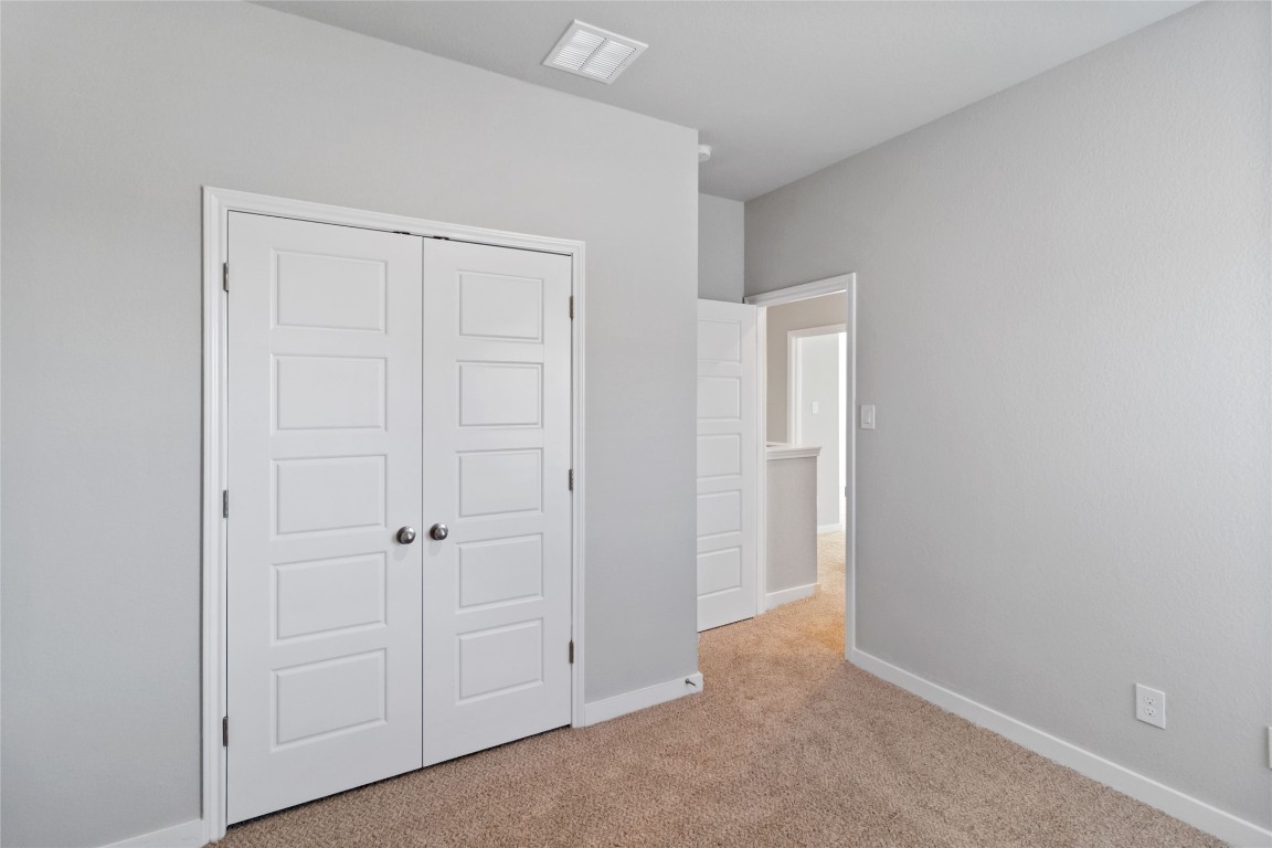 840 Staglin Street, Unit B Buda, TX 78610 - Photo 16 of 17 Unfurnished bedroom featuring light colored carpet and a closet