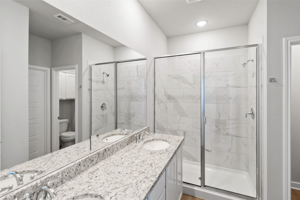 840 Staglin Street, Unit B Buda, TX 78610 - Photo 7 of 17 Full bath featuring a marble finish shower, double vanity, and light wood finished floors