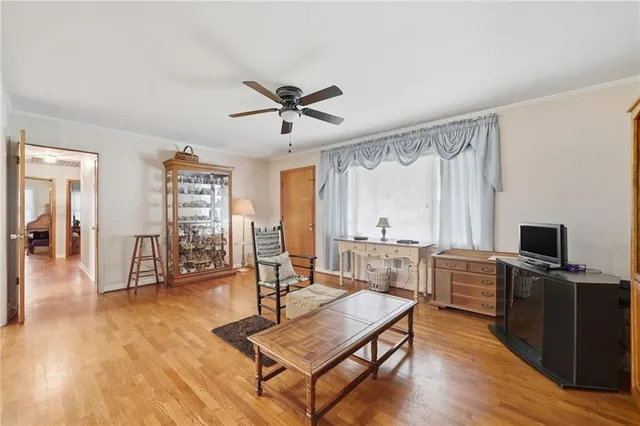 a living room with furniture a flat screen tv and wooden floor