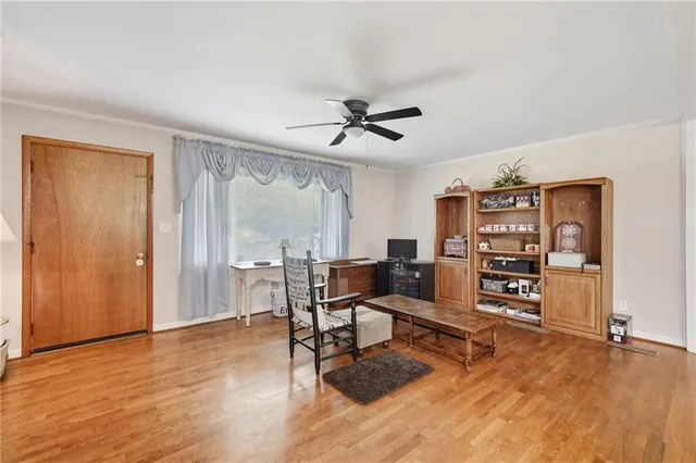 a living room with furniture a desk and chair with wooden floor