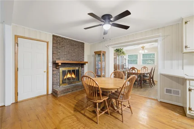 a dining room with furniture a fireplace and wooden floor