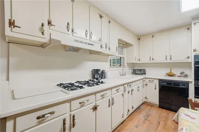 a kitchen with stainless steel appliances granite countertop a sink and cabinets with wooden floor