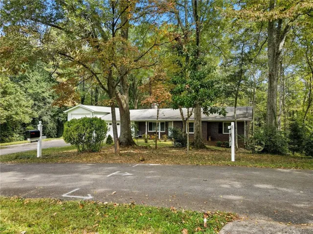 a view of a house with backyard and trees