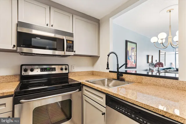 a kitchen with stainless steel appliances granite countertop a refrigerator sink and stove