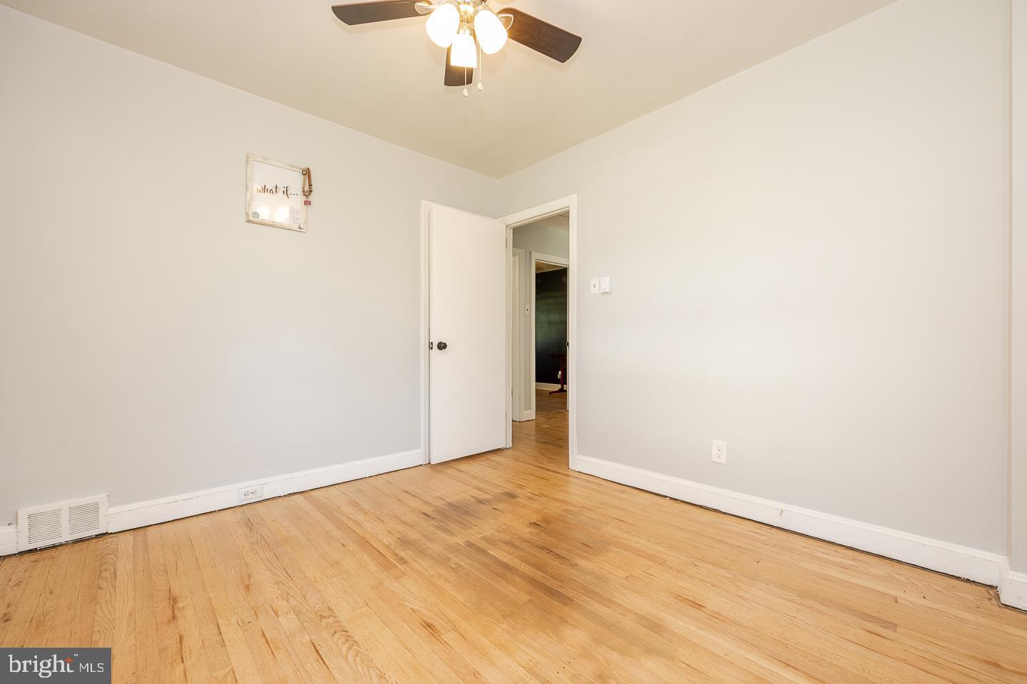 312 Lawrence Road Broomall, PA 19008 - Photo 17 of 23 an empty room with a chandelier fan and wooden floor