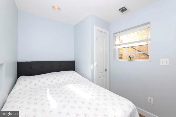a large bed in a bedroom next to a window