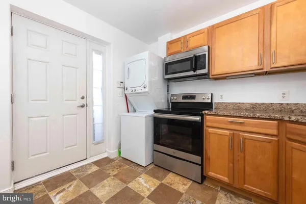 a kitchen with stainless steel appliances granite countertop a stove microwave and refrigerator