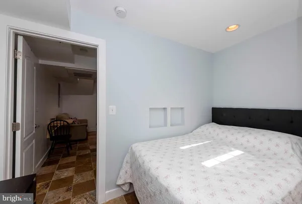 a bedroom with a bed and a large mirror