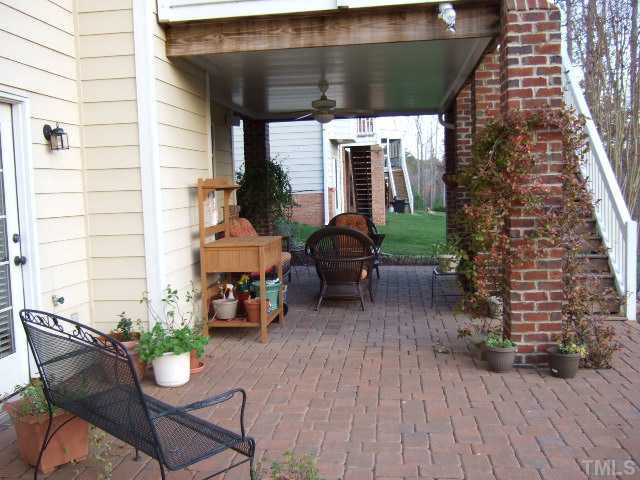 9137 Sanctuary Court Raleigh, NC 27617 - Photo 16 of 17 a view of a patio with table and chairs potted plants with wooden floor
