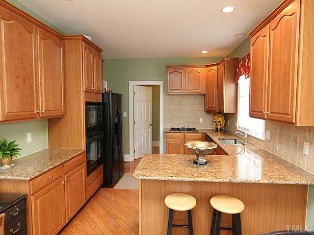 9137 Sanctuary Court Raleigh, NC 27617 - Photo 4 of 17 a kitchen with stainless steel appliances granite countertop a sink refrigerator and cabinets