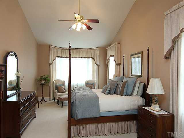 9137 Sanctuary Court Raleigh, NC 27617 - Photo 6 of 17 a bedroom with a bed and a chandelier
