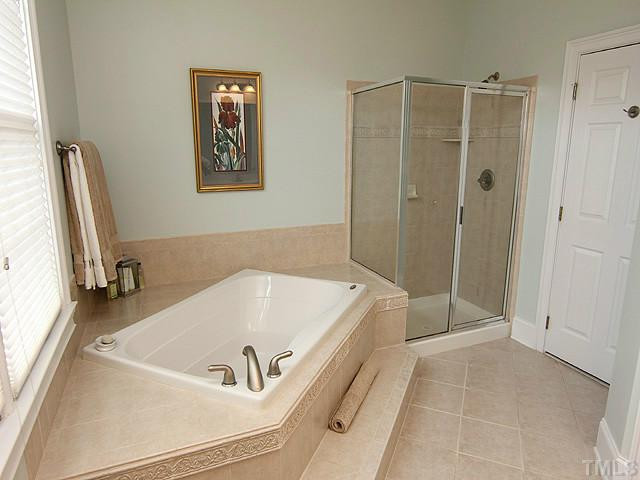 9137 Sanctuary Court Raleigh, NC 27617 - Photo 7 of 17 a bathroom with a tub and a shower