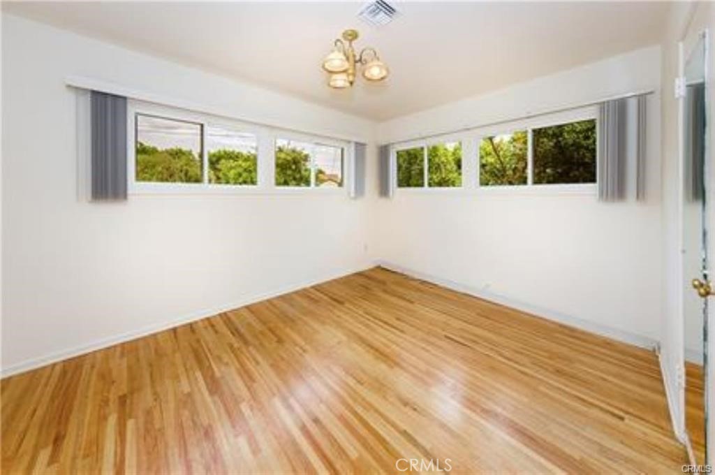 15853 Romar Street North Hills, CA 91343 - Photo 11 of 16 a view of a bedroom with wooden floor and windows