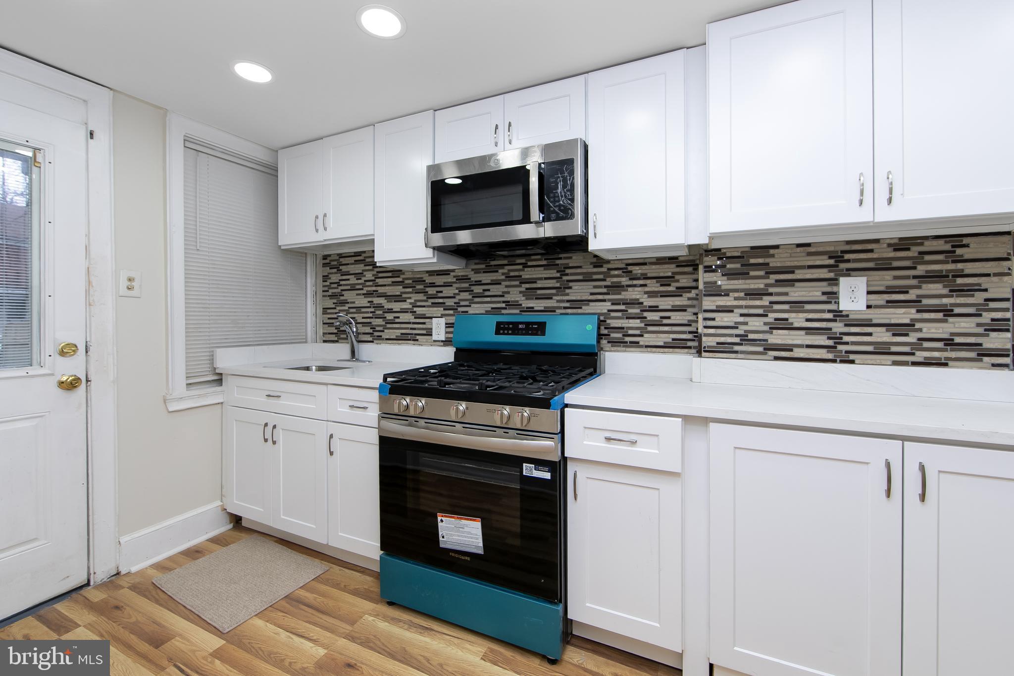 3156 Alabama Road Camden, NJ 08104 - Photo 14 of 31 a kitchen with a stove and a microwave